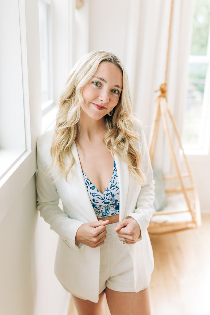 woman posing in white blazer and white shorts