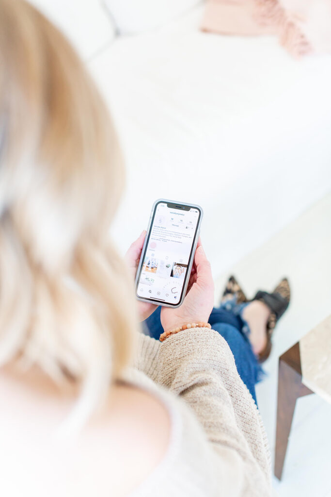 woman holding phone looking at personal brand aesthetic