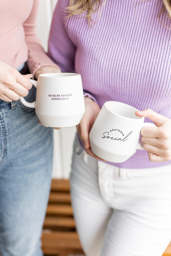 two girls holding branded Southern Social coffee mugs