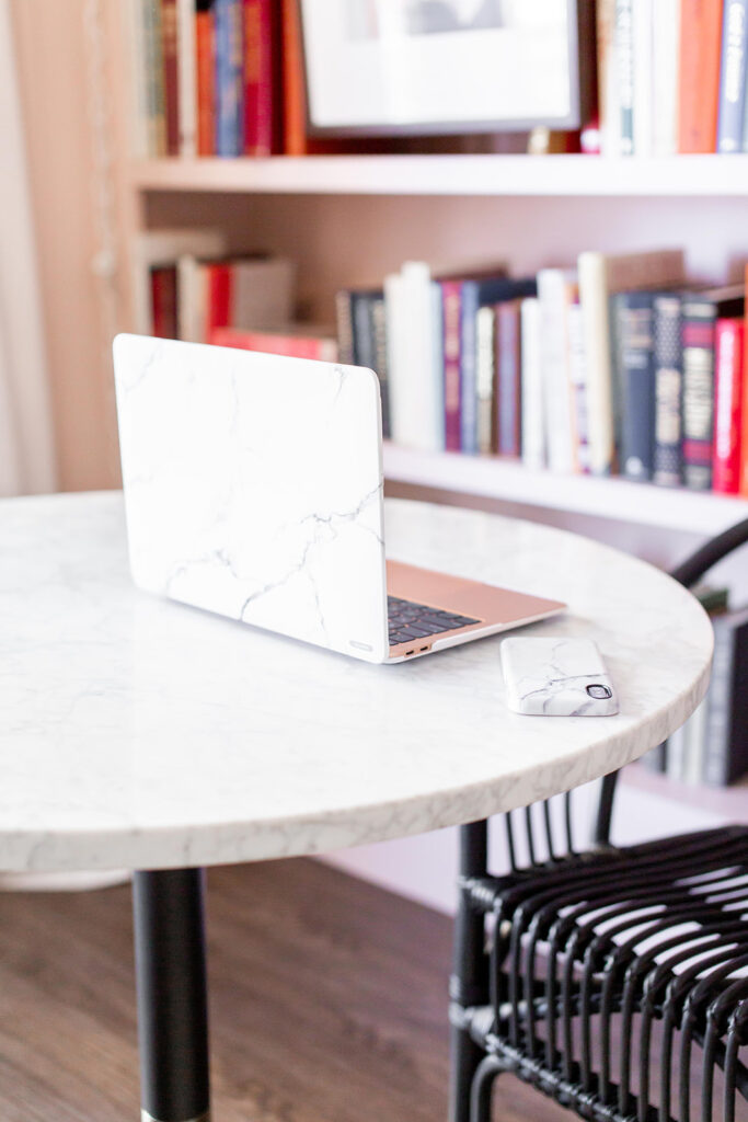 laptop and phone in marble cases on French bistro table