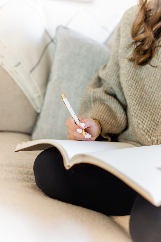 girl writing goals in journal as an end-of-week task