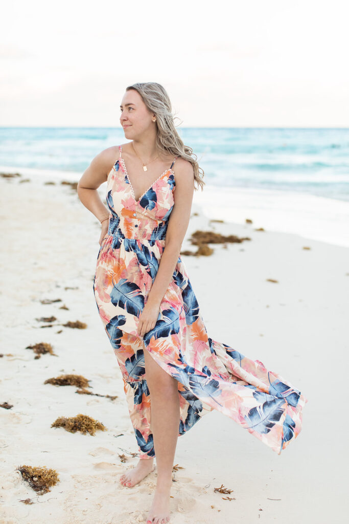woman posing for a summer lifestyle photoshoot on the beach in a floral dress