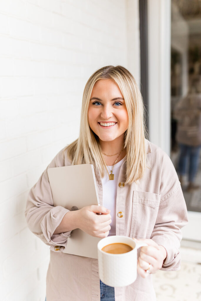 woman smiling holding laptop and coffee