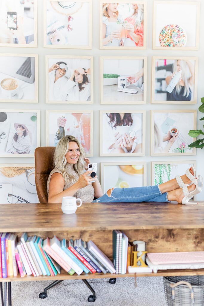 woman at desk with feet up holding phone