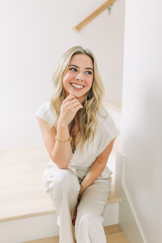 smiling blonde woman in all neutral posing