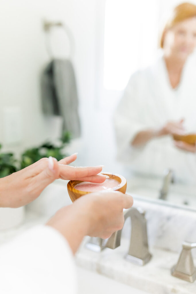 woman dipping fingers into skincare serum