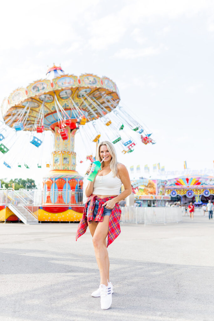 woman posing at fair wearing white sneakers