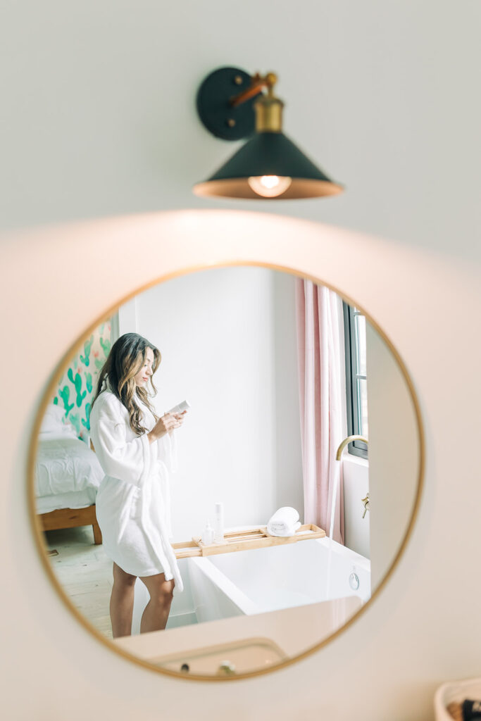 woman in mirror looking at wellness products